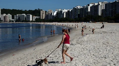 Una mujer camina en una playa en la ciudad de Niterói, vecina de Río de Janeiro hoy, jueves 31 de diciembre de 2020. EFE/Fabio Motta