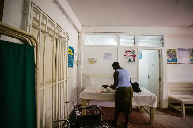 Una mujer cambiando el pañal de un bebé en la Sala de Enfermería y Maternidad de Dunga.