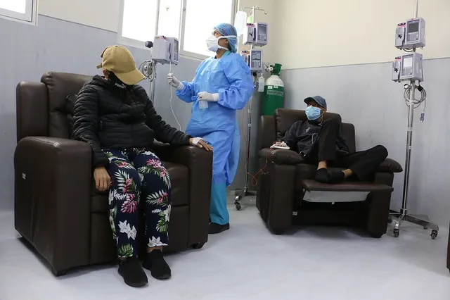 Dos pacients oncológicos recibiento tratamiento de quimioterápia en hospitales