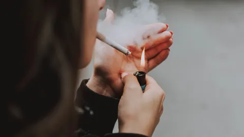 selective-closeup-shot-female-lighting-up-cigarette-with-lighter