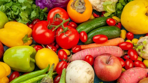 top-view-fruits-and-vegetables-eggplant-bell-peppers-apples-carrot-coriander-cauliflower-persimmon-radish-cherry-tomatoes-on-blue-background